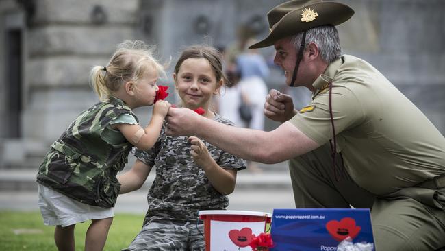 10/11/15 Evie 2 and Valentine 7 Costin (mum Naomi 0403592505) getting poppies from LCPL Zac Butler (0439885726) ahead of Remembrance Day, near the National War Memorial, Adelaide. Picture by Matt Turner.