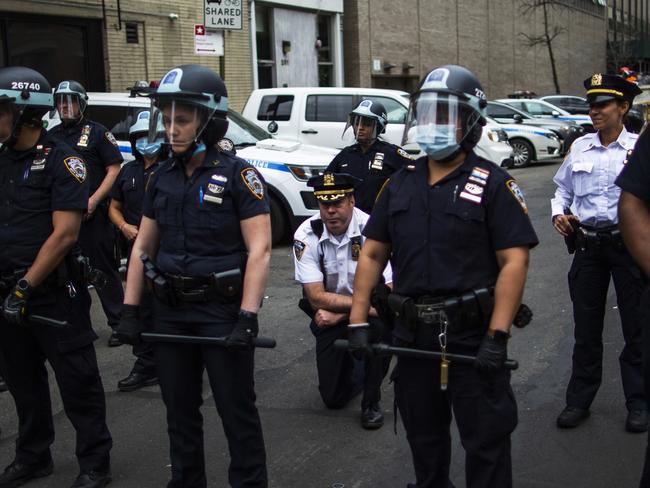 NYPD Deputy Chief McCarthy takes a knee near protesters and other officers as they take part in a march for George Floyd this week. Picture: AP