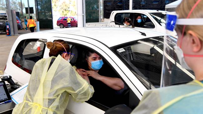 A woman receives a dose of the Pfizer Covid-19 vaccine in Australia’s first drive through vaccination centre in Melton. Picture: AFP