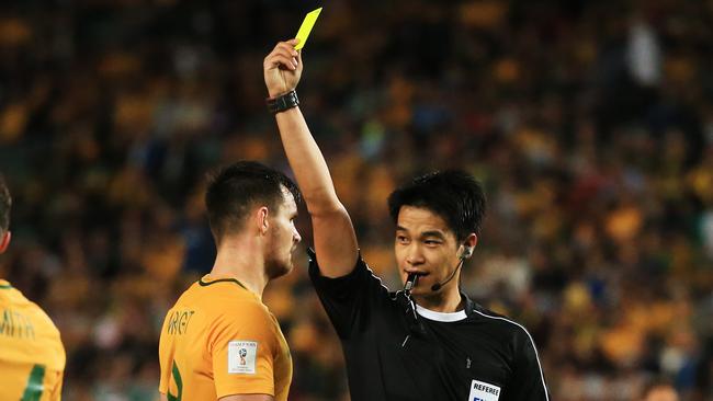 Bailey Wright receives a yellow card during the World Cup qualifier against Jordan.