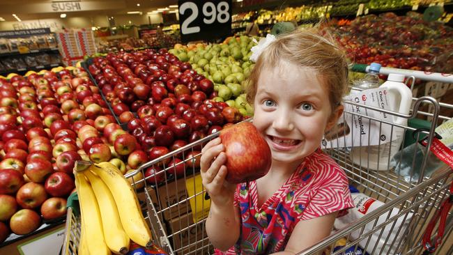 Woolies was commended for offering free fruit to kids at Woolworths stores. Maggie 5, enjoys her apple as she is pushed around the fruit and veg section of the Woolworths Camberwell store in Melbourne. Picture: David Caird.