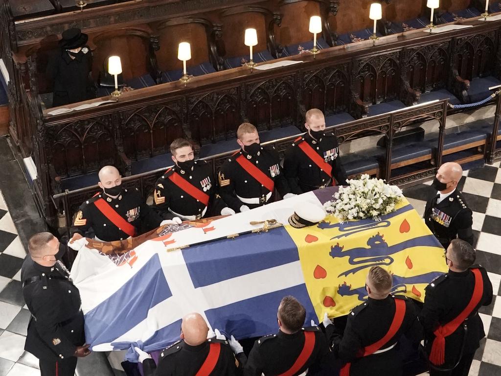 Queen Elizabeth II (left) watches as pall bearers place the coffin of the Duke of Edinburgh during his funeral. Picture: WPA Pool/Getty Images