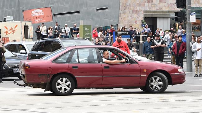 A man doing doughnuts at the intersection of Flinders St and Swanston St. Picture: Tony Gough