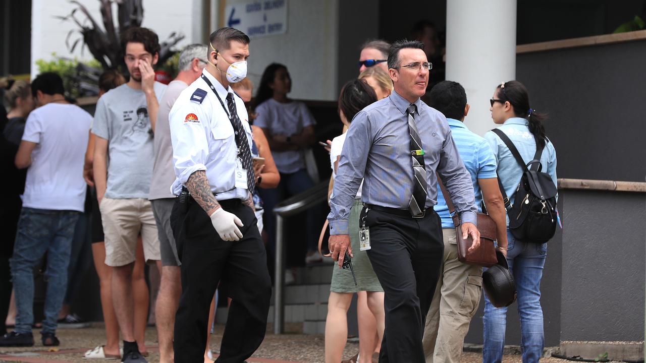 Officials from Centrelink speak to the lines of people waiting at Southport Centrelink. Picture: Adam Head.