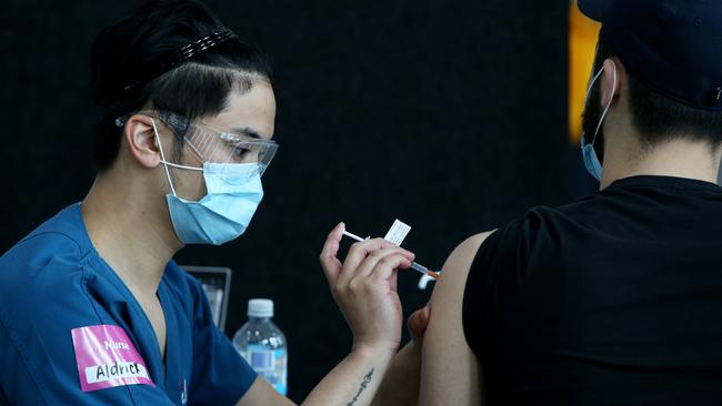 Nurse Aldrick administers a COVID-19 vaccine to a client in Lakemba. Picture: Getty Images