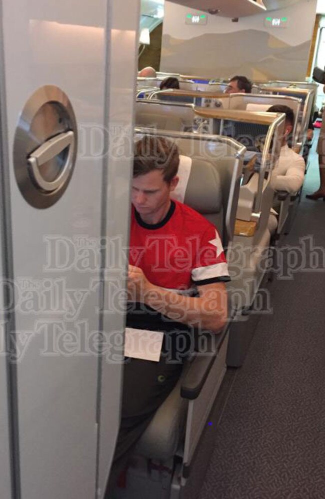 Smith checks his phone en route to Dubai after the press conference.