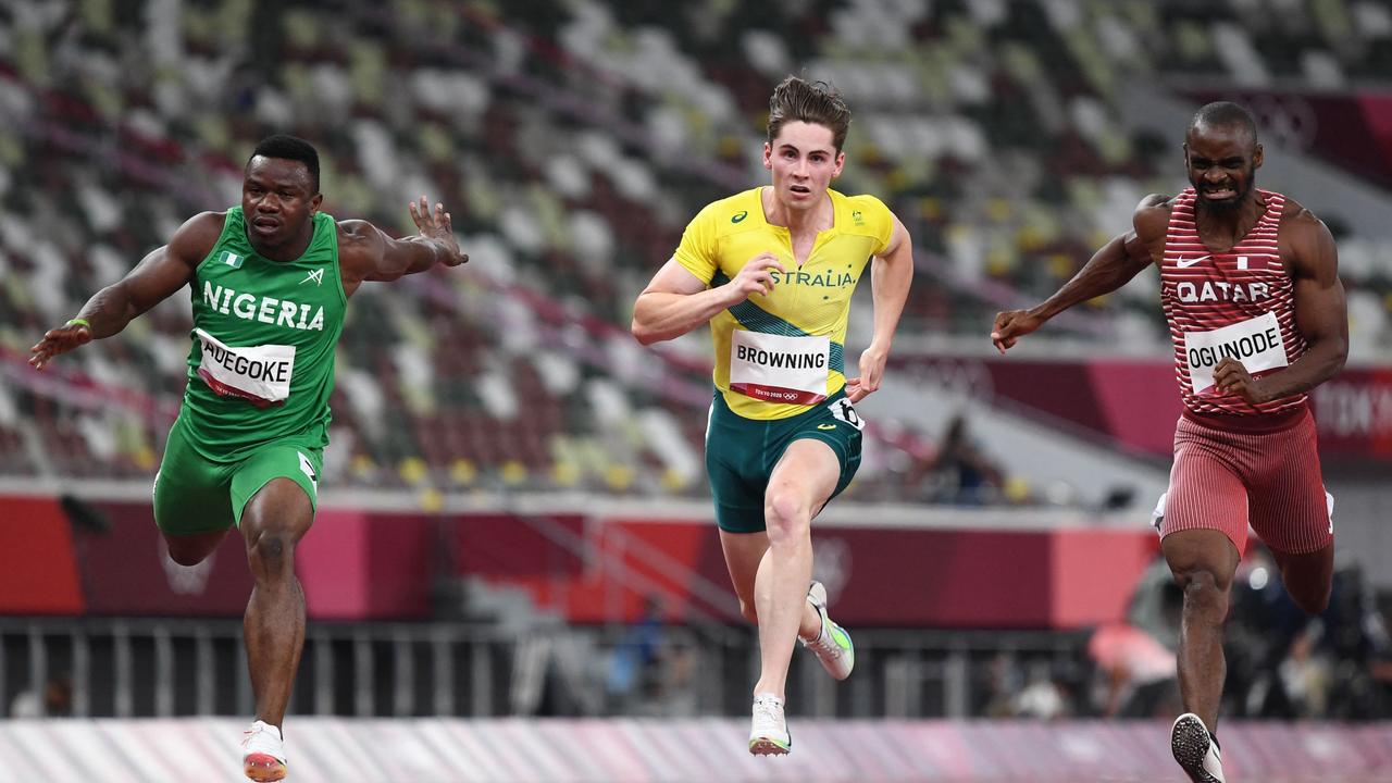 Second-placed Nigeria's Enoch Adegoke (L) crosses the finish line next to Australia's Rohan Browning (C) and Qatar's Femi Ogunode in the men's 100m semi-finals during the Tokyo 2020 Olympic Games at the Olympic Stadium in Tokyo on August 1, 2021. (Photo by Jewel SAMAD / AFP)