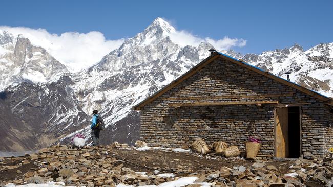 The Annapurna Range looms over a trekker's lodge on Khopra Ridge.