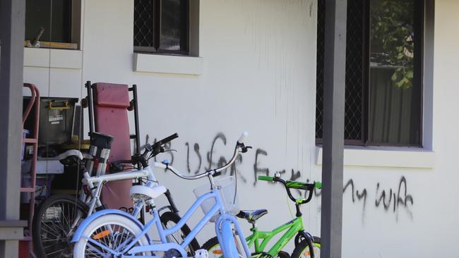 Graffiti on the side of an Ashmore house gutted by fire yesterday. Picture: Glenn Hampson