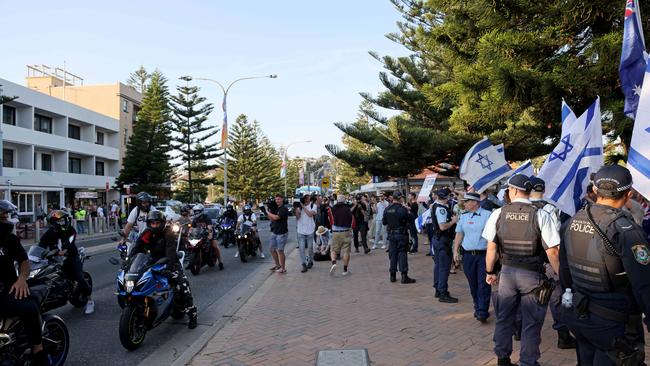 Part of a pro-Palestinian motor convoy passes pro-Israeli supporters at Coogee Beach in Sydney's east on Saturday evening.  Picture: Damian Shaw