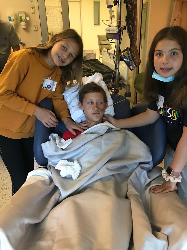 Sister Mea, 11, and cousin Mackenzie at the 12-year-old’s hospital bedside.