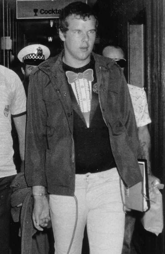 Murderer Andy Albury is led by detectives through the Darwin Airport. Albury was convicted of killing a woman in Darwin's Mitchell Street in November 1983 and mutilating her body. Circa: 8/1984.