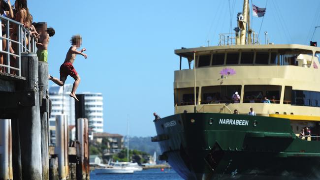 Kids jump off the Manly Wharf, in Sydney Harbour. Picture: Braden Fastier