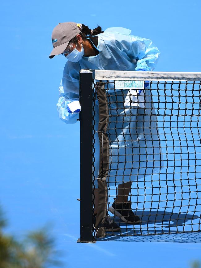 A cleaner wipes down the net after a player's practise session in Melbourne. Picture: AFP