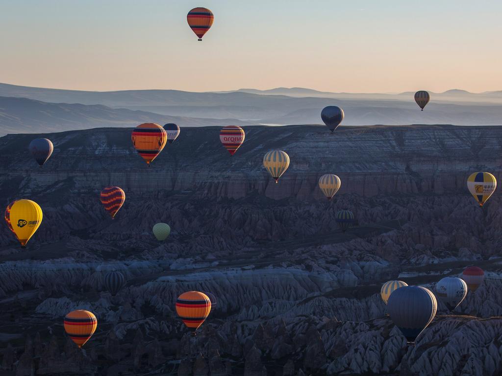 Hot air balloons are seen over rock formations near the town of Goreme on April 17, 2016 in Nevsehir, Cappadocia, Turkey. Picture: Getty