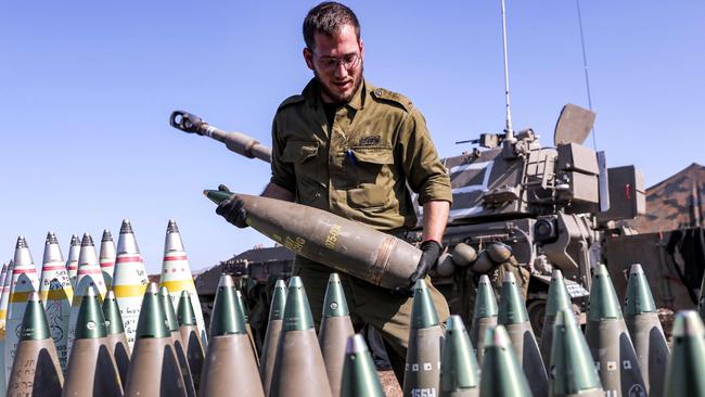 An Israeli soldier carries an artillery shell near the border with Lebanon. Picture: Jalaa Marey/AFP