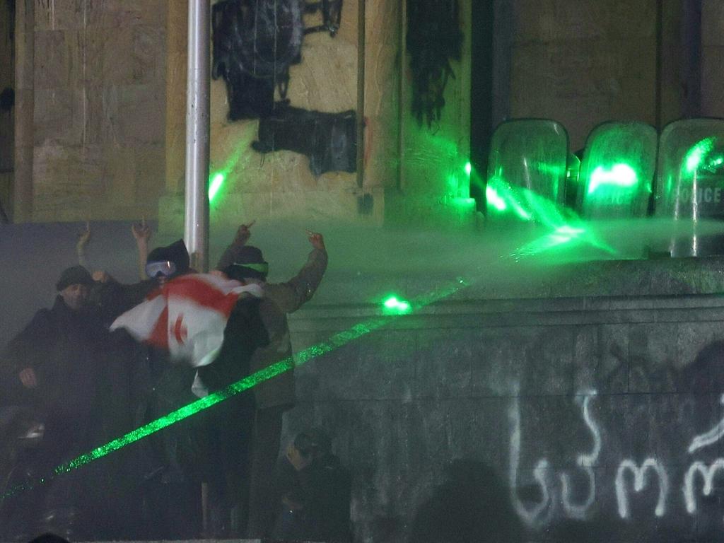 As the riot police shot water cannons at protesters, the protesters used green laser pointers to try and hinder police vision. Picture: Giorgi ARJEVANIDZE / AFP