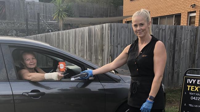 Lisa Carlone takes delivery of a coffee from Ivy Espresso owner Nicole Lewis who introduced a “text, tap and go” service in response to coronavirus.