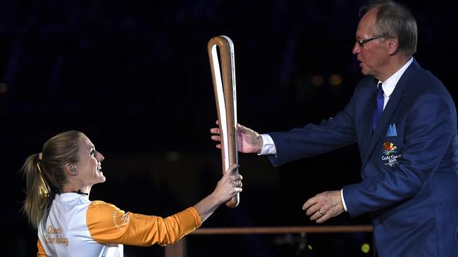 Australian hurdler Sally Pearson hands the Queen's Baton to Gold Coast Commonwealth Games Chairman Peter Beattie during last night’s Opening Ceremony. Photo: AAP