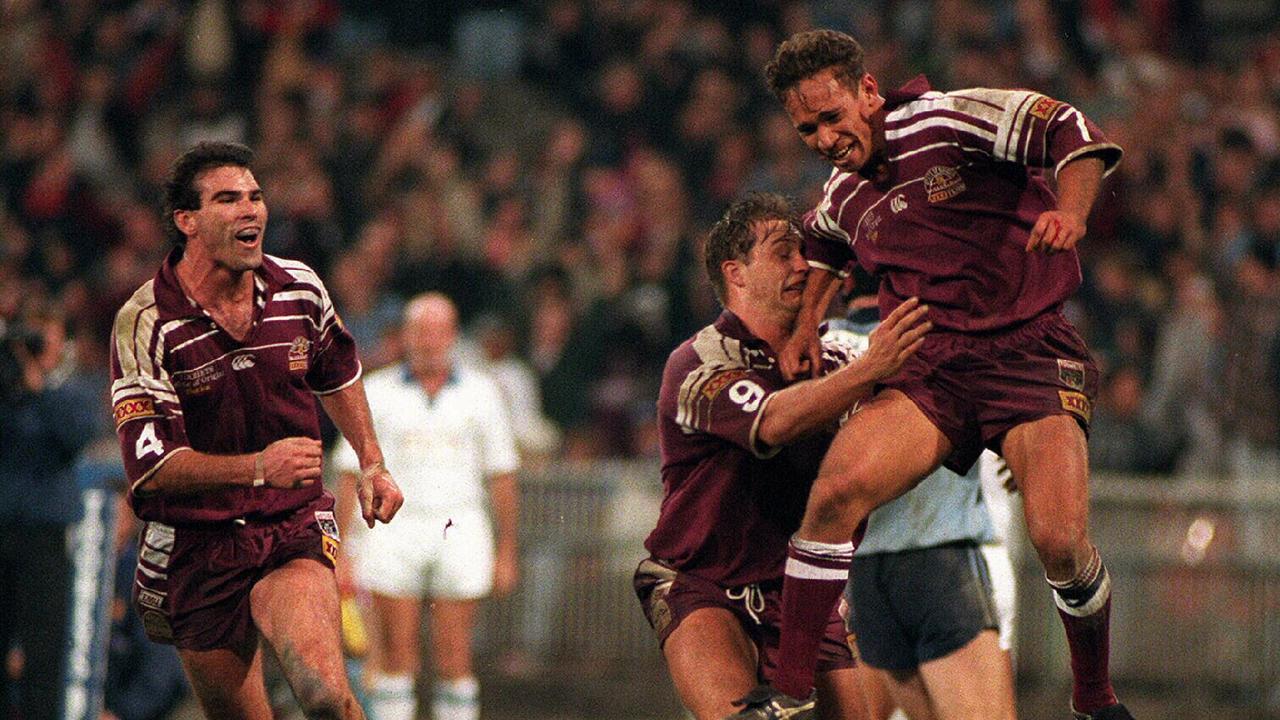 Maroons' Adrian Lam celebrates with team members after scoring try in second game of 1995 State of Origin match. Queensland wins three games this year.