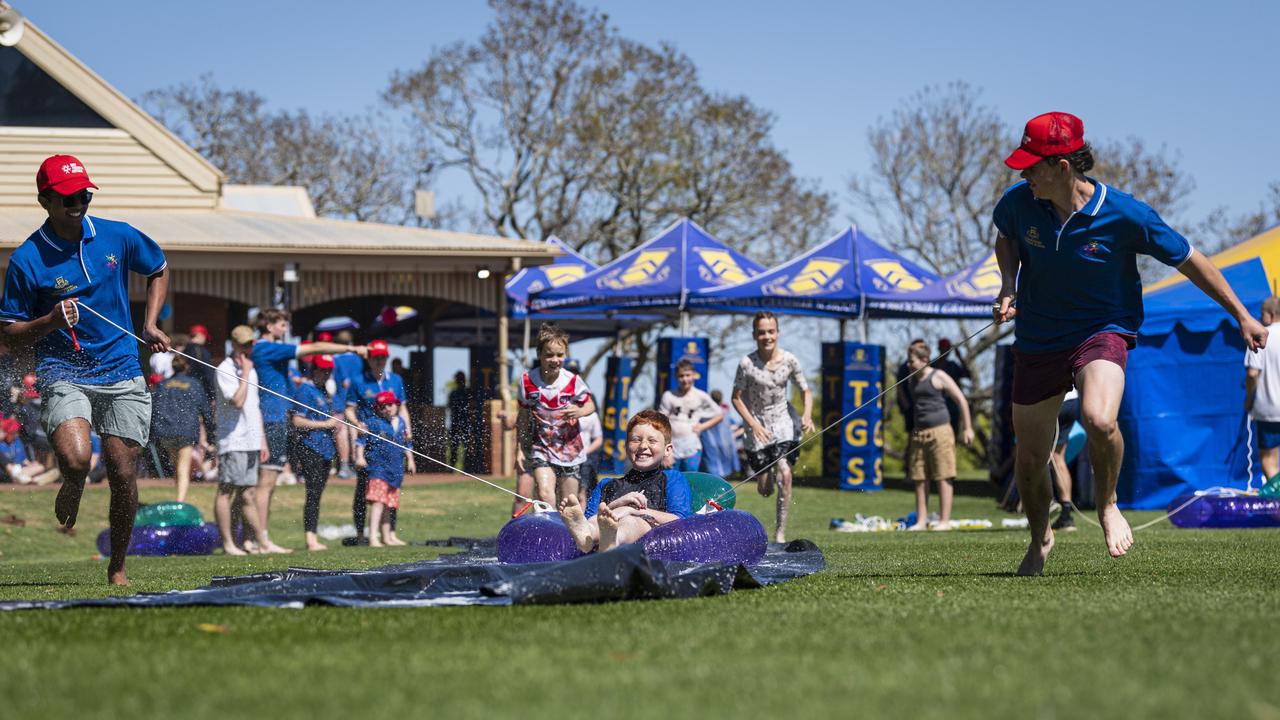 Toowoomba Grammar School students Anuk Fernando (left) and Ned Sullivan take Hunter on the slip and slide as TGS hosts the Sony Foundation Children’s Holiday Camp, Monday, September 16, 2024. Picture: Kevin Farmer