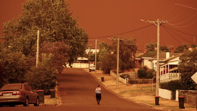 A woman looks down her street as the sky turns red from the fires on January 4, 2020 in Bruthen, in Victoria’s East Gippsland. Picture: Getty