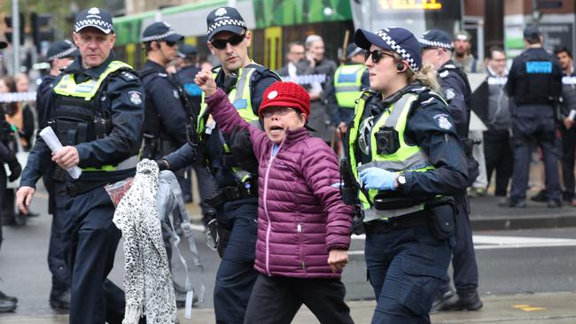 A protester gestures in defiance as she is led away. Picture: AAP Image/David Crosling