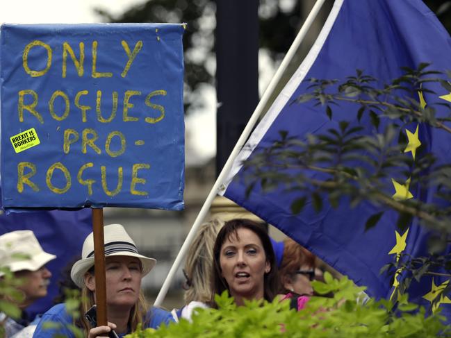 Anti-Brexit supporters wave flags and hold signs at College Green near the Houses of Parliament in central London. Picture: AP