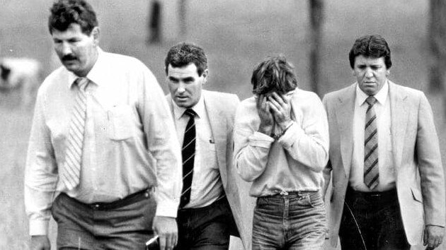 One of Ms Cobby’s killers (third from left) during a renactment with detectives at the paddock in Prospect.