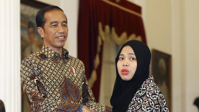 Siti Aisyah, right, formerly accused of killing North Korean leader Kim Jong Un's estranged half brother in Malaysia, thanks Indonesian president Joko Widodo during a meeting at the presidential palace in Jakarta, Indonesia, Tuesday, March 12, 2019. Relatives and neighbors of Aisyah are preparing an emotional welcome home party after the charges against her were unexpectedly dropped. (AP Photo/Achmad Ibrahim)