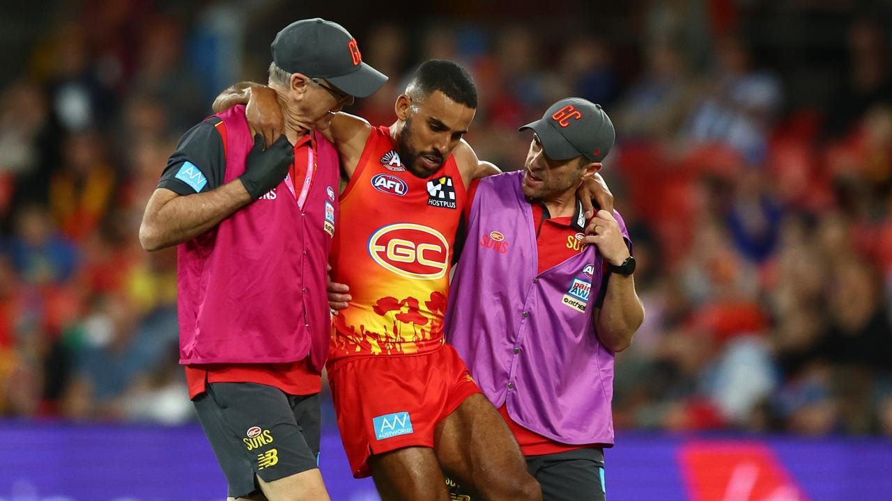 Touk Miller is helped off the field. Picture: Chris Hyde/Getty Images