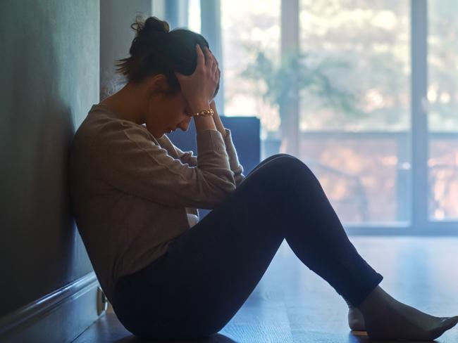 istock generic:  woman, abuse, DV, domestic violence, harassment, sexual harassment.   Sad Young Woman Sitting on the Floor In the Hallway of Her Appartment, Covering Face with Hands. Atmosphere of Depression, Trouble in Relationship, Death in the Family. Dramatic Bad News Moment . Picture: istock