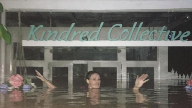 A woman up to her neck in floodwater at Murwillumbah.