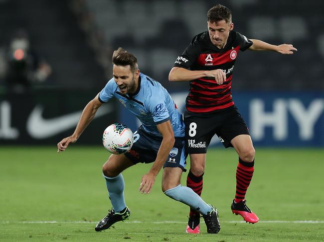 SYDNEY, AUSTRALIA - MARCH 21: Milos Ninkovic of Sydney is tackled by Jordan O'Doherty of the Wanderers during the round 24 A-League match between the Western Sydney Wanderers and Sydney FC at Bankwest Stadium on March 21, 2020 in Sydney, Australia. (Photo by Mark Metcalfe/Getty Images)