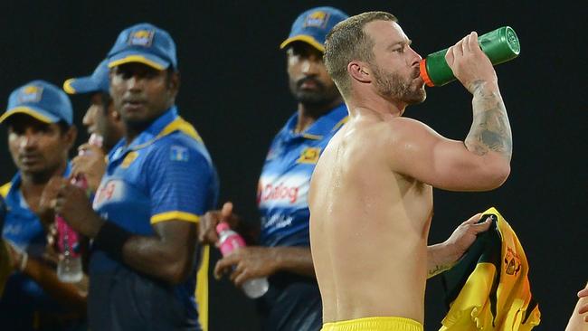 Australia's Matthew Wade (R) takes a drinks break ... with his shirt off.