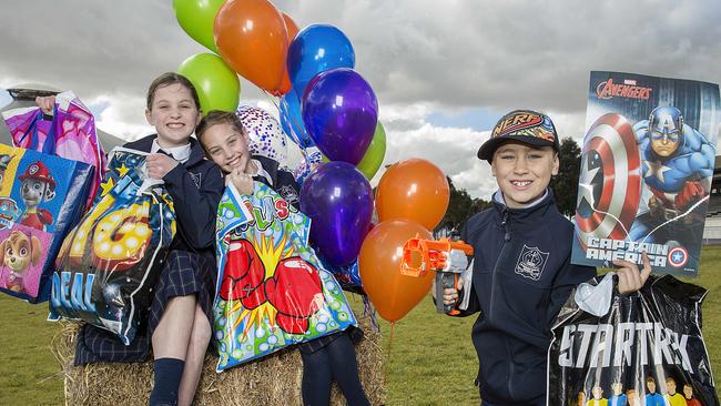 St Margaret Mary's Primary School students Nancy, Mishi and Liam testing out some of this years showbags at the Royal Melbourne Show. Picture: Ian Currie