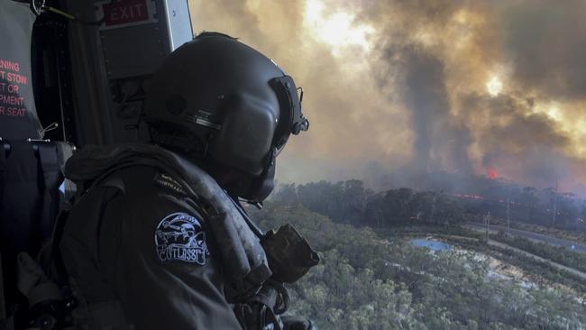 Royal Australian Navy Aircrewman, Petty Officer Jason Wickman assesses the Grose Valley bushfire in the Blue Mountains National Park.