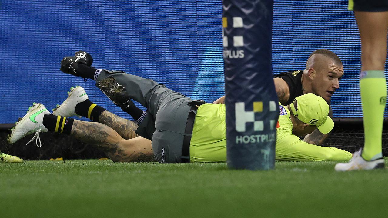 Dustin Martin crashes into goal umpire Adam Wojcik after getting his toe to the ball on the goal-line. Picture: Michael Klein