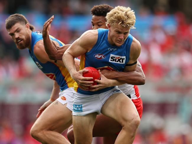 Bodhi Uwland of the Suns is tackled. (Photo by Cameron Spencer/Getty Images)