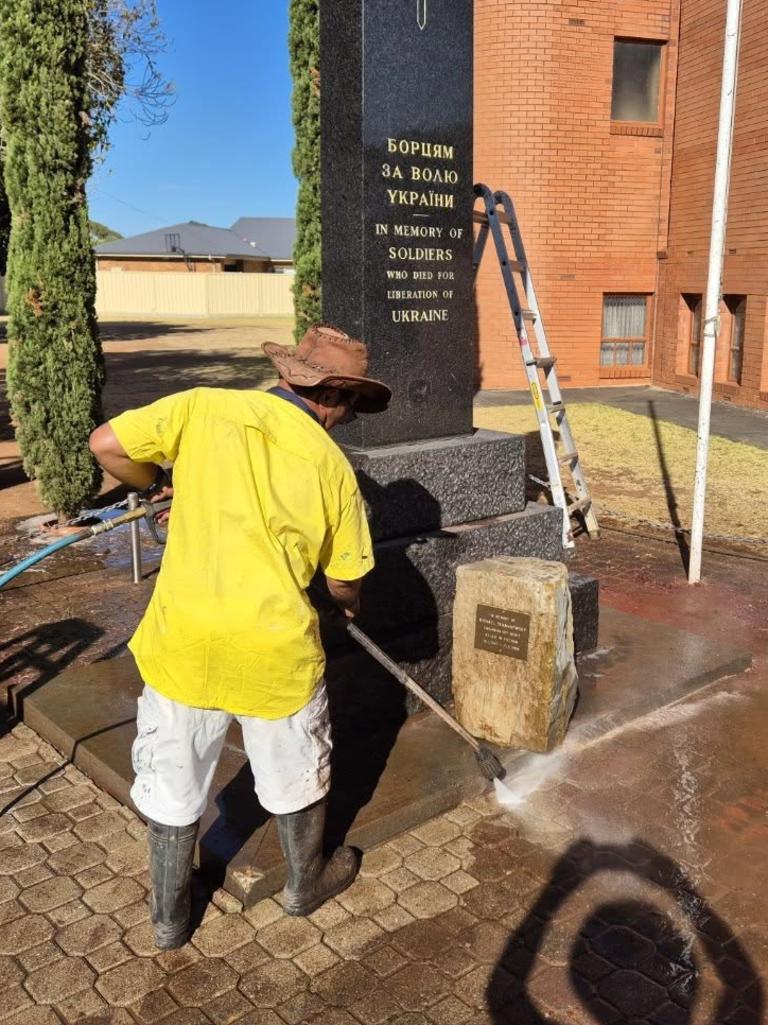 Workers clean up the red paint. Picture: Patrick Ryan