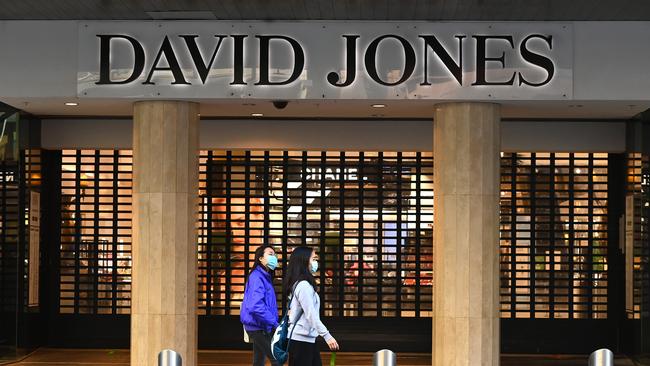 People wearing face masks walk down an empty Bourke Street Mall. Picture: Getty