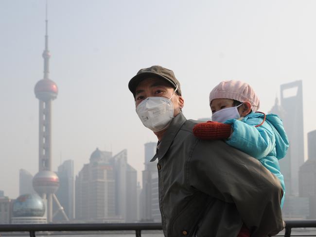 SHANGHAI, CHINA - DECEMBER 25:  (CHINA OUT) A man and his child wear masks as they visit The Bund on December 25, 2013 in Shanghai, China. Heavy smog covered many parts of China on Christmas Eve, worsening air pollution.  (Photo by VCG/VCG via Getty Images)