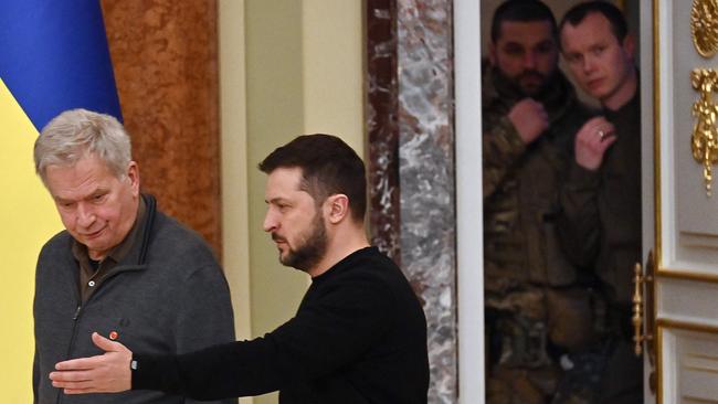 Ukrainian security officers look out from a door as Ukrainian President Volodymyr Zelensky greets his Finnish counterpart Sauli Niinisto following talks in Kyiv.