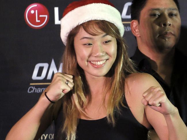 FILE - In this Dec. 10, 2015, file photo, mixed martial arts fighter Angela Lee, of Singapore, poses wearing a Santa hat, following a weigh-in ceremony for her One Championship bout, at the Mall of Asia Arena at suburban Pasay city south of Manila, Philippines. Lee didn't need the UFC to become one of the world's top up-and-coming mixed martial artists. Instead, the 20-year-old Canadian-born Hawaiian fights for One Championship, Asia's dominant MMA promotion. (AP Photo/Bullit Marquez, File)