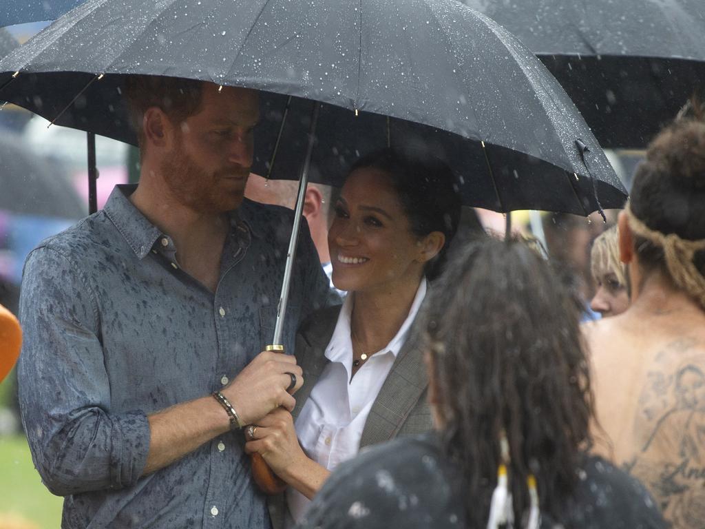 This was the other adorable moment Harry ditched his own umbrella to snuggle in with Meghan. Picture: Ian Vogler/AP