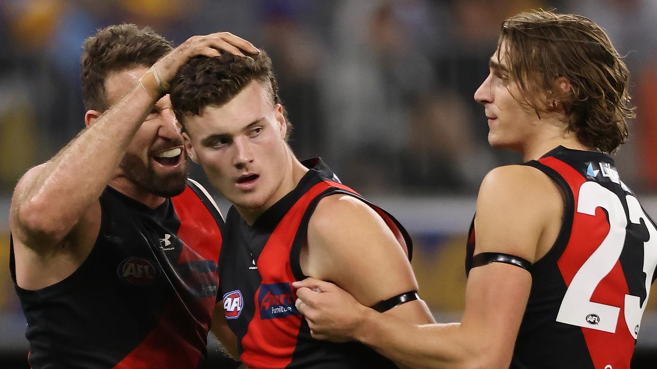 PERTH, AUSTRALIA - MAY 29: Nikolas Cox of the Bombers celebrates a goal with Cale Hooker and Harrison Jones during the round 11 AFL match between the West Coast Eagles and the Essendon Bombers at Optus Stadium on May 29, 2021 in Perth, Australia. (Photo by Paul Kane/Getty Images)