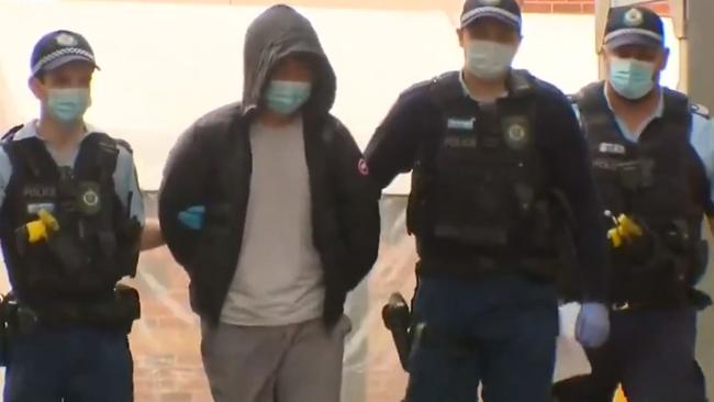 Yang Zhao, who is wanted in connection with the alleged murder of a person found hidden in a metal box at a Brisbane riverside apartment, is taken into police custody. Picture: 9 News