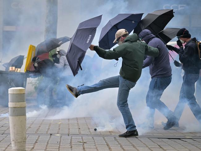 TOPSHOT - Demonstrators react as they are enveloped by teargas during an anti far-right rally after the French president called legislative elections following far-right parties' significant gains in European Parliament elections, in Rennes, western France on June 15, 2024. (Photo by LOU BENOIST / AFP)