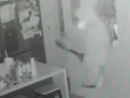 A man was filmed wandering through a suburban home armed with two weapons.