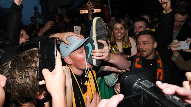 Tigers fans celebrate their team's victory in the 2019 AFL Grand Final by drinking out of a shoe. Picture: AAP Image/Erik Anderson